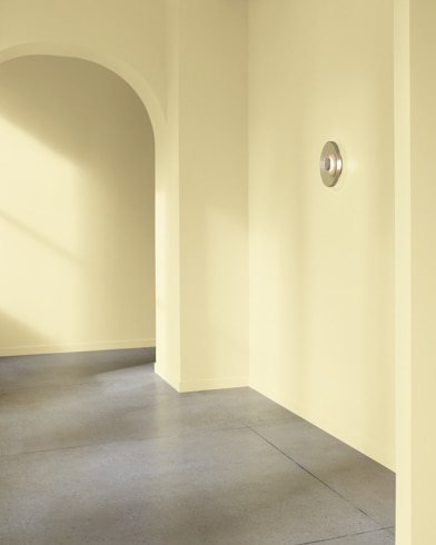 An arched hallway in a modern home is painted Hampton Green.