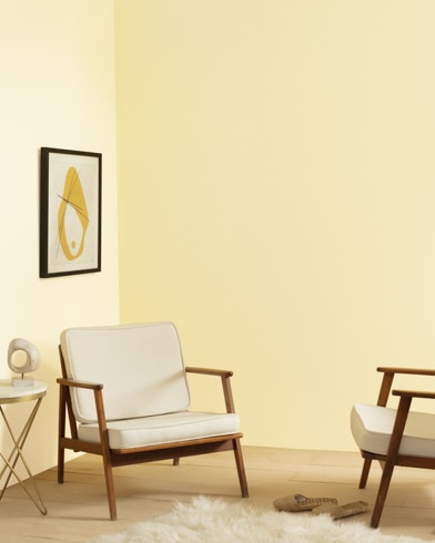 A living room with two chairs, a modern lamp, and shag carpet is painted Weston Flax.