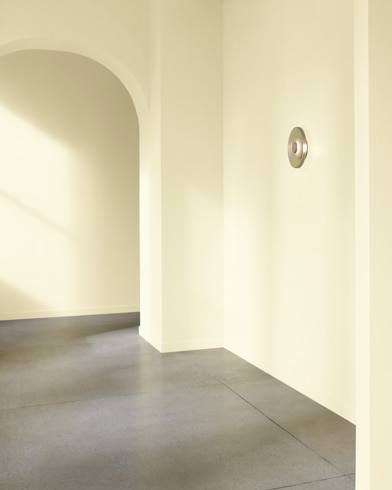 An arched hallway in a modern home is painted Pale Celery.